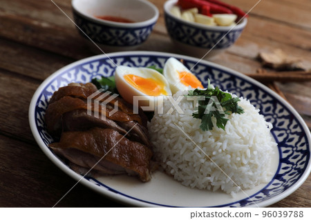 Local Thai food stewed pork leg on rice isolated in wood background Local Thai food stewed pork leg on rice isolated in wood background 96039788
