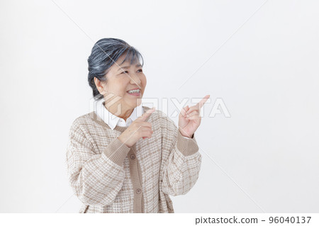 Pointing senior woman white background 96040137