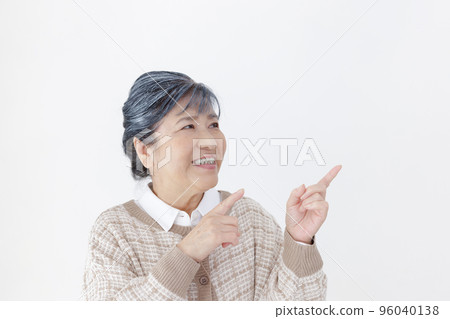 Pointing senior woman white background 96040138