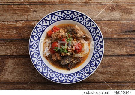Local northern thai food Rice noodles with pork in spicy soup in wood background 96040342