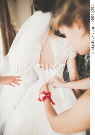Gorgeous bride in robe posing and preparing for the wedding ceremony face in a room Gorgeous bride in robe posing and preparing for the wedding ceremony face in a room 96040399