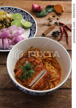 Local northern Thai food Egg noodle curry with fried pork on wood background Local northern Thai food Egg noodle curry with fried pork on wood background 96040438