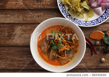Local northern Thai food Egg noodle curry with pork ribs on wood background Local northern Thai food Egg noodle curry with pork ribs on wood background 96040680