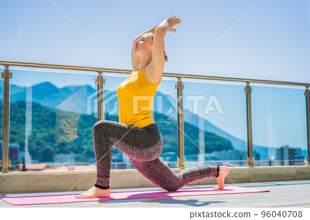 Beautiful woman doing yoga outdoors on a rooftop terrace Beautiful woman doing yoga outdoors on a rooftop terrace 96040708