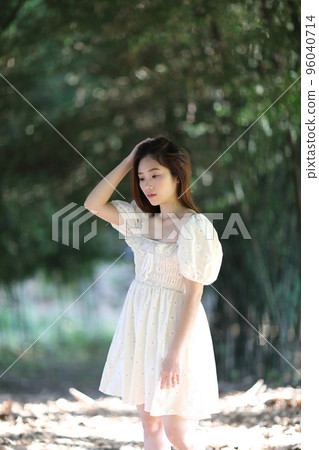 Beautiful young woman with white dress on bamboo forest background Beautiful young woman with white dress on bamboo forest background 96040714