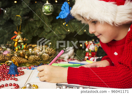Little boy in Santa hat writes letter to Santa Claus Little boy in Santa hat writes letter to Santa Claus 96041171