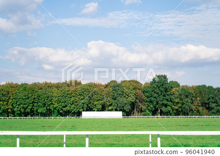 Empty high-speed track at hippodrome for horse racing near dense green forest Empty high-speed track at hippodrome for horse racing near dense green forest 96041940