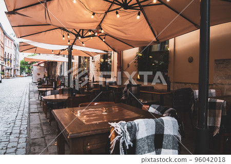 Spend time on terrace: cozy street cafe interior with wooden wicker chairs and blooming hydrangea. Garden or dacha restaurant outside city. Stylish patio at hotel or spa. Design and decoration concept Spend time on terrace: cozy street cafe interior with wooden wicker chairs and blooming hydrangea. Garden or dacha restaurant outside city. Stylish patio at hotel or spa. Design and decoration concept 96042018