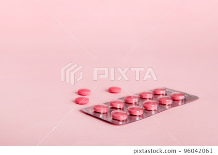 Blister package with Vitamin on color background. Medicine pills on a light background. Medicines and prescription pills flat lay background. pink medical tablets in blister 96042061