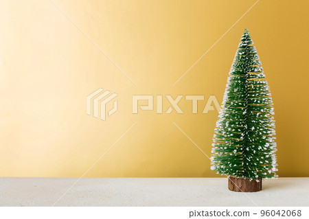 One small Christmas tree on colored background. new year decoration with copy space One small Christmas tree on colored background. new year decoration with copy space 96042068