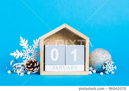 1 january. Christmas composition on colored background with a wooden calendar, with a gift box, toys, bauble copy space 1 january. Christmas composition on colored background with a wooden calendar, with a gift box, toys, bauble copy space 96042078