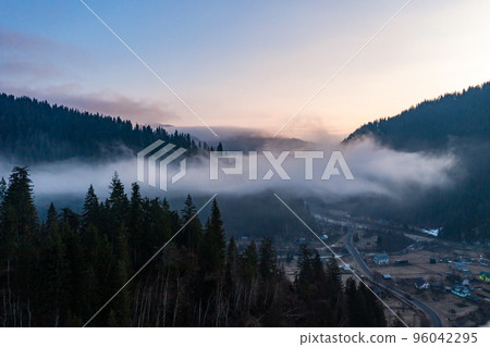 Panorama of a Ukrainian mountain village, a view of the village among the clouds from above. Panorama of a Ukrainian mountain village, a view of the village among the clouds from above. 96042295