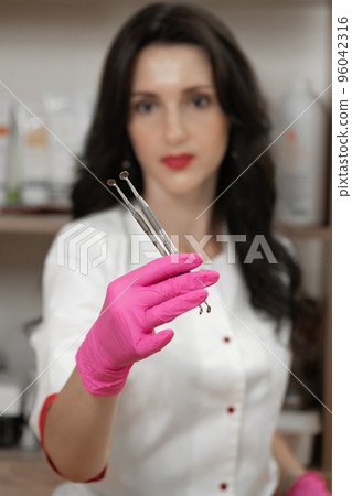 Uno spoons in the hands of a cosmetologist, tools of a cosmetologist for cleaning the face. Uno spoons in the hands of a cosmetologist, tools of a cosmetologist for cleaning the face. 96042316