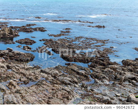 Rocky seashore, landscape. Calm water surface on a sunny day. 96042672