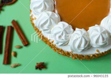 Caramel cake with nuts and caramel sauce glaze. whipped cream with cinnamon. rounded tart or pie Caramel cake with nuts and caramel sauce glaze. whipped cream with cinnamon. rounded tart or pie 96043135