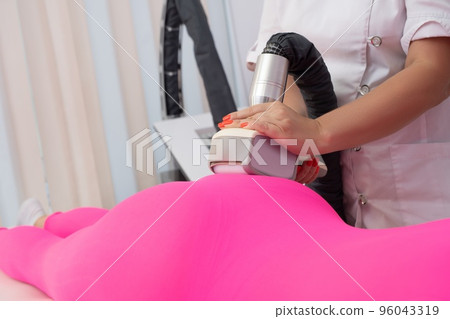 Crop masseuse doing vacuum massage to female customer Crop masseuse doing vacuum massage to female customer 96043319