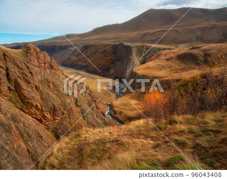 Majestic autumn mountain landscape. Autumn mountain valley. Bright sunny autumn landscape with sunlit gold valley and winding river on gorge under dramatic sky. Majestic autumn mountain landscape. Autumn mountain valley. Bright sunny autumn landscape with sunlit gold valley and winding river on gorge under dramatic sky. 96043408