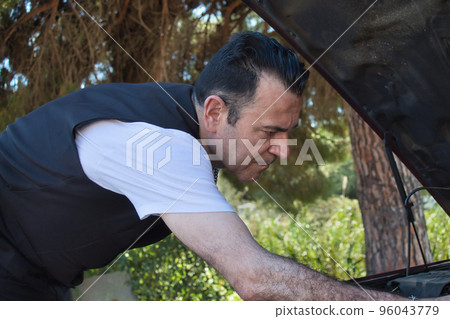 mature man repair a fault in his car engine on the road mature man repair a fault in his car engine on the road 96043779
