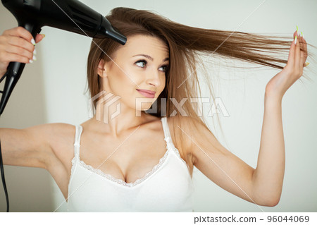 Beautiful long haired woman drying hair in bathroom 96044069
