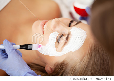 Beautiful woman with facial mask at beauty salon 96044174