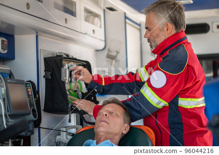 Ambulance physician preparing the patient for oxygenation Ambulance physician preparing the patient for oxygenation 96044216