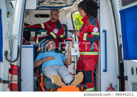 Ambulance staff listening to the sick man complaints 96044221
