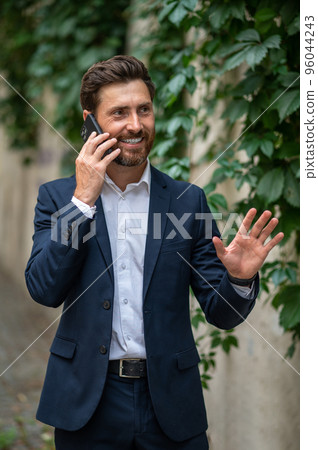 Good-looking young man talking on the phone and looking excited 96044243