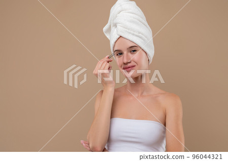 Pretty young girl pluckinh her eyebrows 96044321