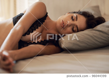 Sleeping delight. Gorgeous brunette asleep on a bed. 96044399