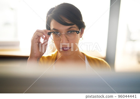 Bringing her vision of success into focus. Cropped shot of a young creative working on a computer in an office. Bringing her vision of success into focus. Cropped shot of a young creative working on a computer in an office. 96044441