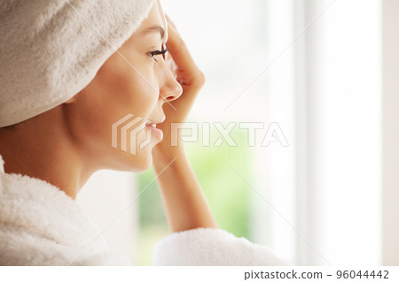Perfect young woman applying facial cream in bathroom Perfect young woman applying facial cream in bathroom 96044442