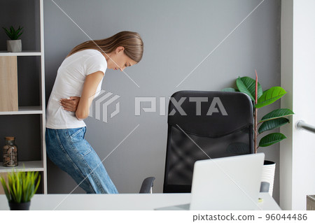 Business woman feeling painful from stomach ache illness during working at office 96044486