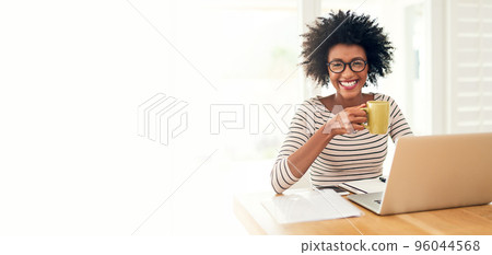 Nothing like a cup of comfort to start the day. Cropped portrait of a young woman drinking coffee while working on her laptop at home. 96044568