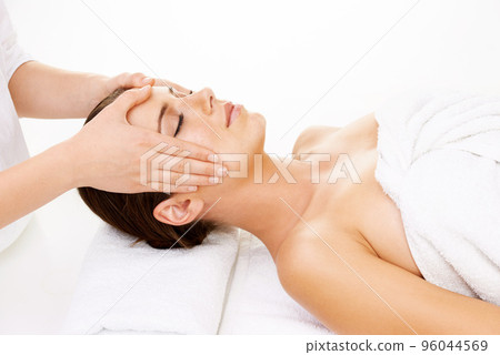 Getting in the right head space. Cropped shot of a young woman getting a beauty treatment isolated on white. Getting in the right head space. Cropped shot of a young woman getting a beauty treatment isolated on white. 96044569