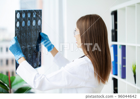 Female doctor examining MRI image in hospital Female doctor examining MRI image in hospital 96044642