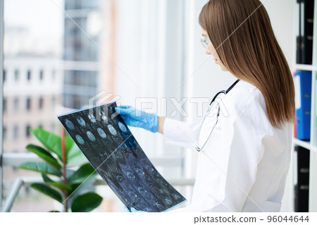 Female doctor examining MRI image in hospital Female doctor examining MRI image in hospital 96044644
