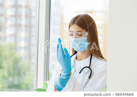 Female doctor with protective mask and gloves in hospital Female doctor with protective mask and gloves in hospital 96044666