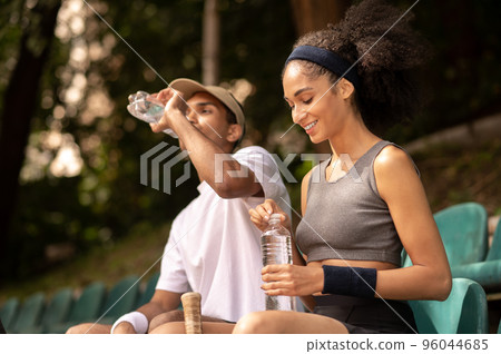 Two tennis players resting after the game and looking contented 96044685
