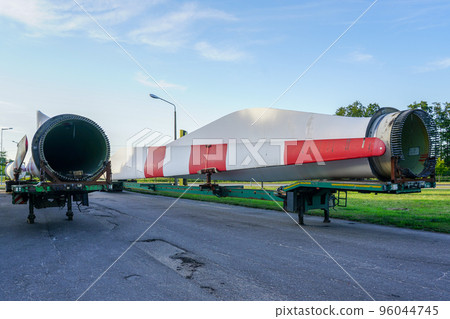 Low-loader semi-trailer with oversized used wind generator parts in the parking lot 96044745