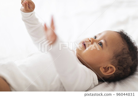 Closeup Shot Of Cute Little African American Toddle Boy Lying On Bed Closeup Shot Of Cute Little African American Toddle Boy Lying On Bed 96044831