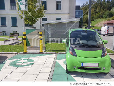 Modern electric car plugged in, charging on the street station. New energy vehicles, environment friendly alternative energy for cars Modern electric car plugged in, charging on the street station. New energy vehicles, environment friendly alternative energy for cars 96045060