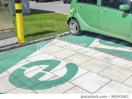 Modern electric car plugged in, charging on the street station. New energy vehicles, environment friendly alternative energy for cars Modern electric car plugged in, charging on the street station. New energy vehicles, environment friendly alternative energy for cars 96045061