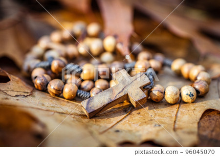 Wooden rosary beads lying on autumn leaves. 96045070