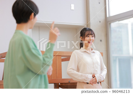 A young woman practicing vocalization while being taught by a voice trainer_1 A young woman practicing vocalization while being taught by a voice trainer_1 96046213