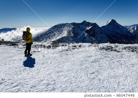 Yatsugatake mountain range in severe winter, climbers on the summit of Mt. Iodake and the ridgeline of Mt. Yokodake 96047446