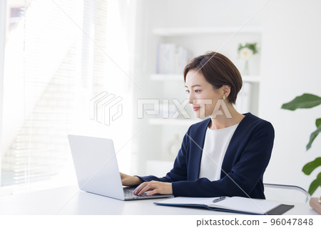 Business Portrait of a woman working on a personal computer Business Portrait of a woman working on a personal computer 96047848