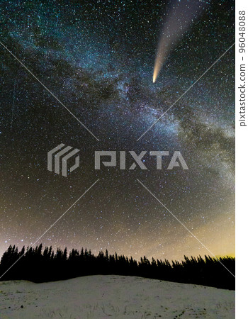 Surreal view of night in mountains with starry dark blue cloudy sky and C/2020 F3 (NEOWISE) comet with light tail. Surreal view of night in mountains with starry dark blue cloudy sky and C/2020 F3 (NEOWISE) comet with light tail. 96048088