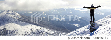 Silhouette of alone tourist standing on snowy mountain top in winner pose with raised hands enjoying view and achievement on bright sunny winter day. Adventure, outdoors activities, healthy lifestyle. Silhouette of alone tourist standing on snowy mountain top in winner pose with raised hands enjoying view and achievement on bright sunny winter day. Adventure, outdoors activities, healthy lifestyle. 96048117