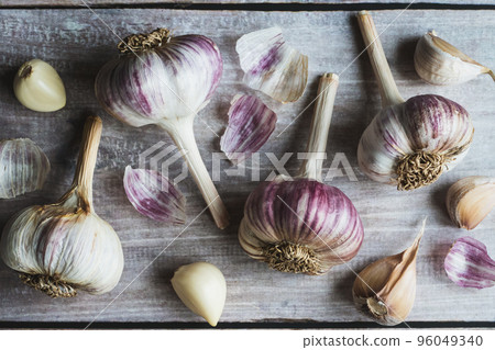 Garlic on wooden table, garlic bulbs and cloves food background, flat lay Garlic on wooden table, garlic bulbs and cloves food background, flat lay 96049340