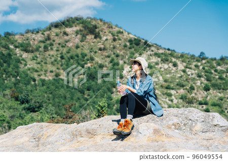 Woman taking a break from climbing 96049554